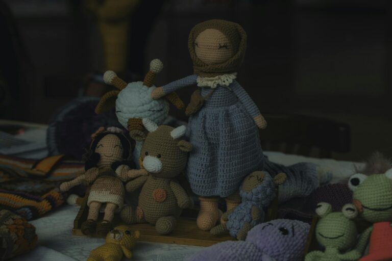 A collection of handmade knitted dolls and stuffed animals, perfect for children.