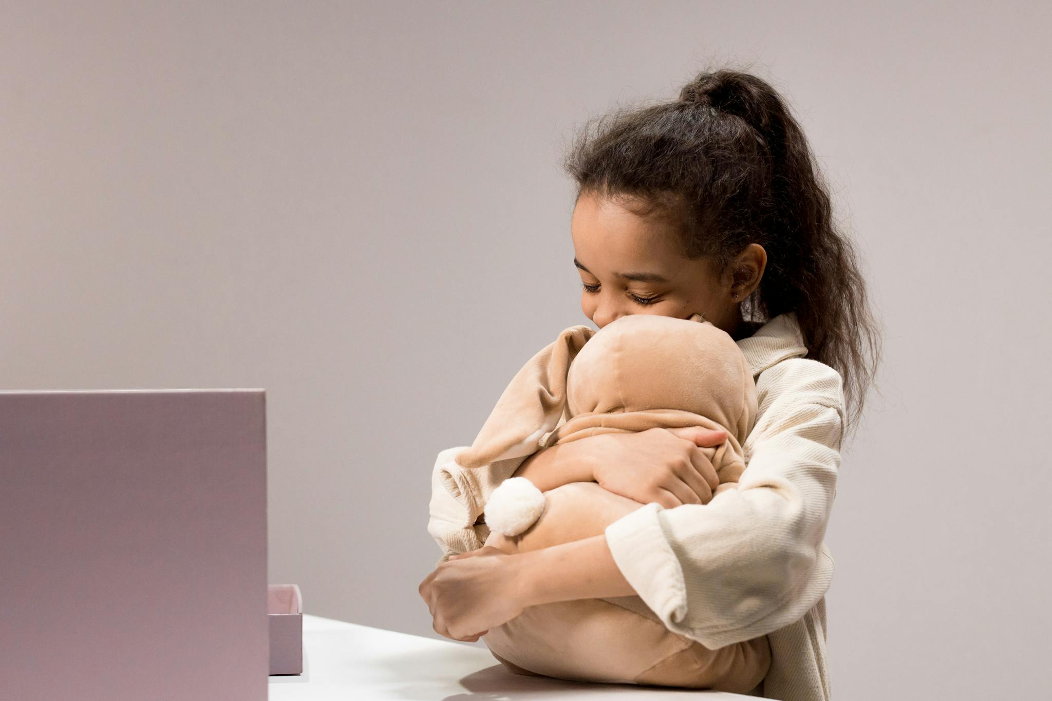 A joyful girl hugging a plush toy, capturing childhood innocence and happiness.