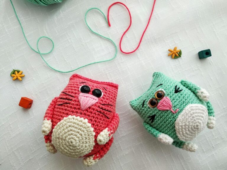 Cute crochet cat toys with yarn forming a heart on a white background.