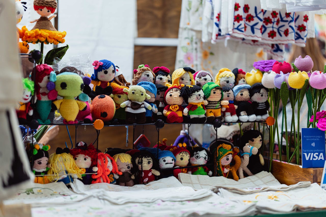 Colorful crochet dolls on display at a market stall in Ciudad de México.